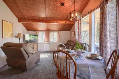 a dining room with a table and chairs and a couch at Wyandot Woods - Squirrels Nest in Laurelville