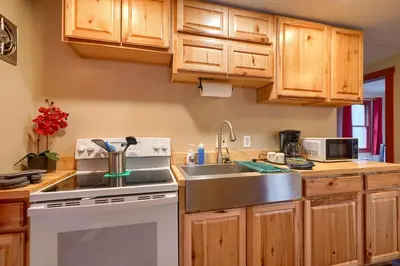 a kitchen with wooden cabinets and a sink and a stove at Wyandot Woods - Firefly in Laurelville