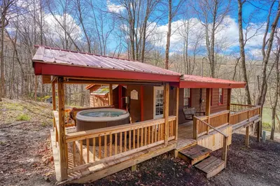 a small cabin with a hot tub in the woods at Wyandot Woods - Firefly in Laurelville