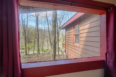 a window of a house with a view of the woods at Wyandot Woods - Firefly in Laurelville