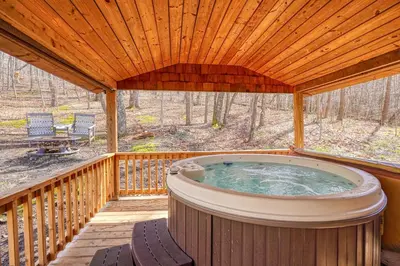 a hot tub on a deck with a wooden ceiling at Wyandot Woods - Firefly in Laurelville