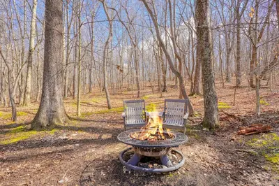 two chairs and a fire pit in the woods at Wyandot Woods - Firefly in Laurelville