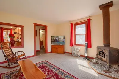 a living room with a wood stove and red curtains at Wyandot Woods - Firefly in Laurelville