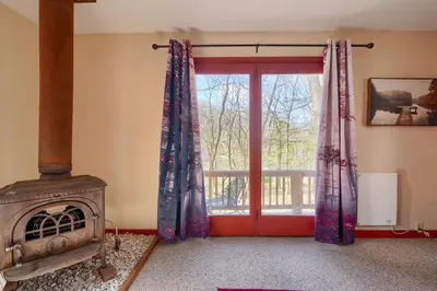 a room with a fireplace and a window with curtains at Wyandot Woods - Firefly in Laurelville