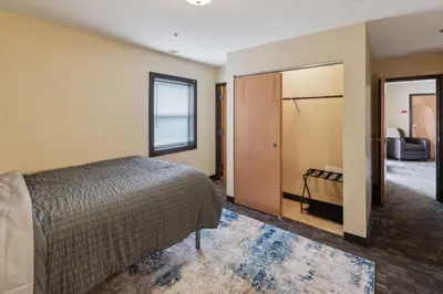 a bedroom with a bed and a door leading to a bathroom at Spacious and Modern Stay to Relax & Recharge in Mansfield