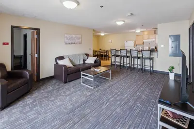 a living room with a couch and a table and a kitchen at Spacious and Modern Stay to Relax & Recharge in Mansfield