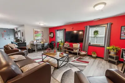 a living room with red walls and leather furniture at Spacious and Modern Stay to Relax & Recharge in Mansfield