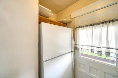 a refrigerator in a kitchen next to a window at Home 2 Mi to Lakewood Park and Solstice Steps! in Lakewood