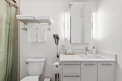 a white bathroom with a toilet and a sink at Downtown Free Parking Garage - 5 min walk OTR in Cincinnati