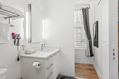 a white bathroom with a sink and a toilet at Downtown Free Parking Garage - 5 min walk OTR in Cincinnati