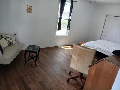 a room with a bed and a couch and a window at Branson House Bed & Breakfast in Marion