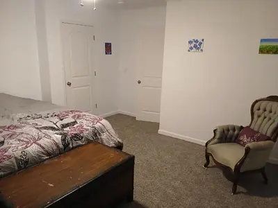a bedroom with a bed and a chair and a table at Branson House Bed & Breakfast in Marion