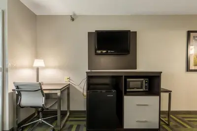a hotel room with a desk and a tv at Quality Inn Grove City - Columbus South in Grove City