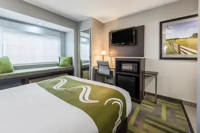 a hotel room with a bed and a flat screen tv at Quality Inn Grove City - Columbus South in Grove City
