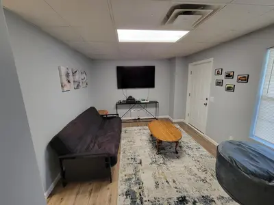 a living room with a couch and a flat screen tv at The Third Monkey in Williamstown