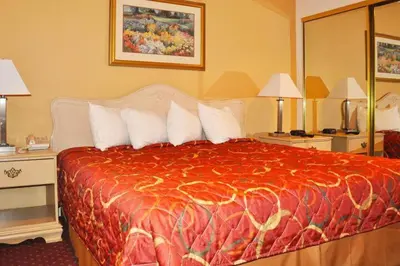 a hotel room with a bed with a red comforter at Avalon Inn in Sandusky