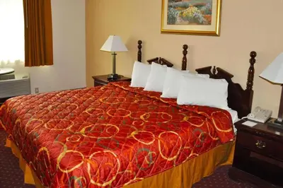 a hotel room with a bed with a red bedspread at Avalon Inn in Sandusky