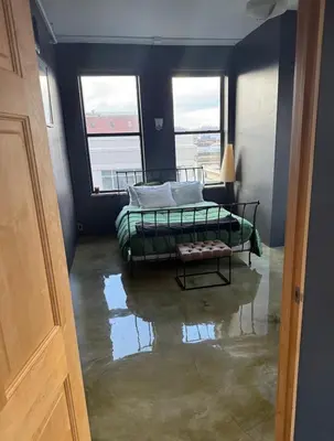 a flooded room with a bed and two windows at Lee Flat in Charleston