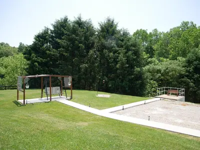 a park with two benches in the grass at PineRidge Country Retreat with In ground Pool and Hot Tub in Langsville