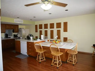 a kitchen with a large island with chairs around it at PineRidge Country Retreat with In ground Pool and Hot Tub in Langsville