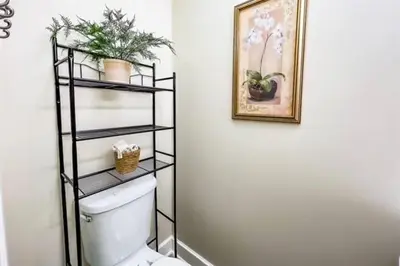 a bathroom with a toilet with a shelf above it at Coastal Retreat in Sandusky