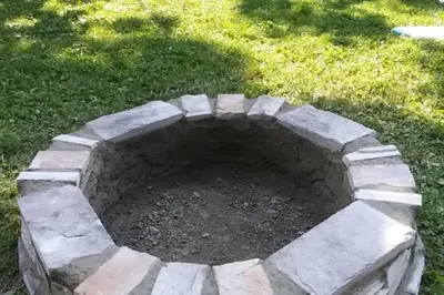 a stone fire pit in the middle of a yard at Coastal Retreat in Sandusky