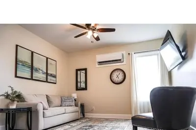 a living room with a couch and a clock on the wall at Coastal Retreat in Sandusky