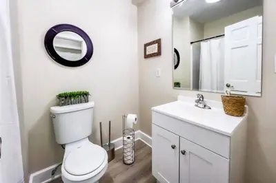 a bathroom with a toilet and a sink and a mirror at Coastal Retreat in Sandusky