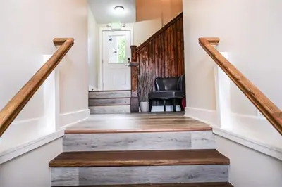 a hallway with a staircase with a chair and a door at Coastal Retreat in Sandusky