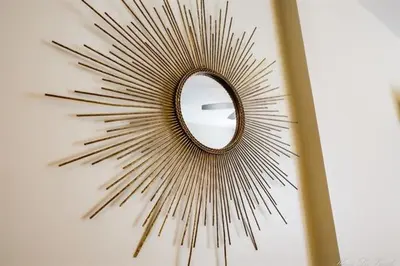 a mirror with a starburst mirror on a wall at Coastal Retreat in Sandusky