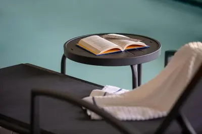 a table with a book and a chair on it at Fairfield Inn & Suites by Marriott Akron Fairlawn in Montrose
