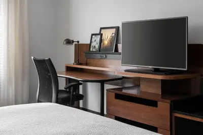 a bedroom with a desk with a television and a chair at Fairfield Inn & Suites by Marriott Akron Fairlawn in Montrose