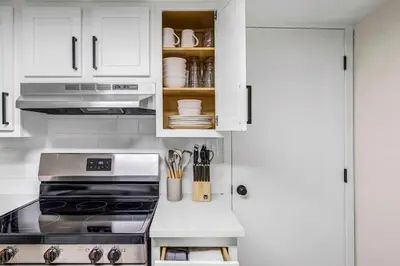 a kitchen with white cabinets and a stove at New Renovated 1BR with King Modern Comfort in Berea