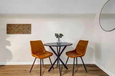 a table with two chairs and a vase of flowers at New Renovated 1BR with King Modern Comfort in Berea