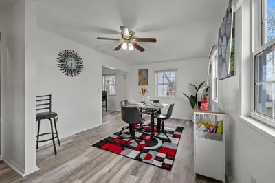 a living room with a ceiling fan and a table at Cosy house, home away from home in Grove City