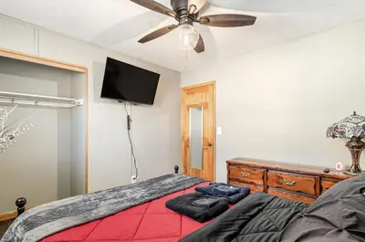 a bedroom with a red bed and a flat screen tv at Gates getaway in Columbus