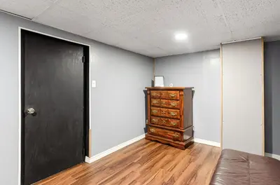 an empty room with a black door and a dresser at Gates getaway in Columbus