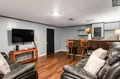 a living room with two leather couches and a bar at Gates getaway in Columbus