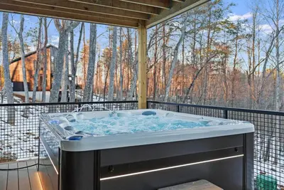 a hot tub on a deck with a view of trees at Adamina Canyon Luxurious 5BR 3BTH 2 in Rockbridge