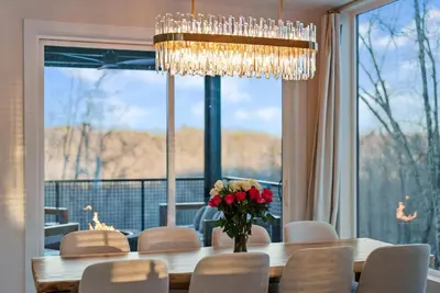 a dining room with a table with a vase of flowers at Adamina Canyon Luxurious, Canyon View 5BR 3BTH 3 in Rockbridge