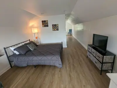 a bedroom with a bed and a flat screen tv at Bright Studio Stay Downtown in Columbus