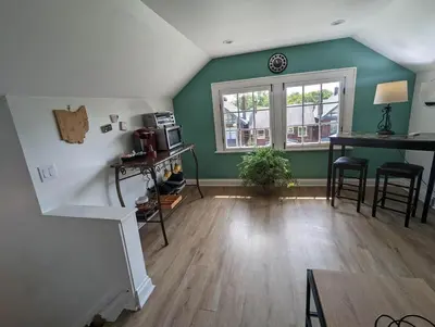 a living room with green walls and a window at Bright Studio Stay Downtown in Columbus