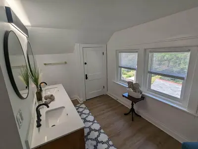 a white bathroom with a sink and two windows at Bright Studio Stay Downtown in Columbus