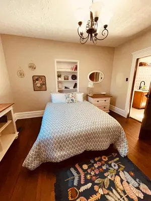 a bedroom with a bed and a chandelier at Paisley Garden House Near Kings Daughters Hospital in Ashland