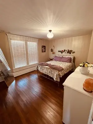 a bedroom with a bed and a wooden floor at Paisley Garden House Near Kings Daughters Hospital in Ashland