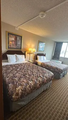 a hotel room with two beds and two lamps at Napoleon Inn and Suites in Napoleon