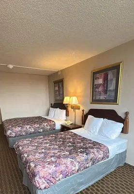 a hotel room with two beds and two lamps at Napoleon Inn and Suites in Napoleon