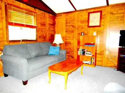 a living room with a couch and a coffee table at Rustic Cabin Rental near Akron, Ohio in Dellroy