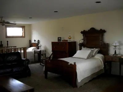 a bedroom with a bed and a chair and a couch at Peaceful Getaway on a Lovely Farm near Hillsboro, Ohio