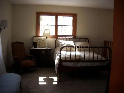 a bedroom with a bed and a window and a chair at Peaceful Getaway on a Lovely Farm near Hillsboro, Ohio